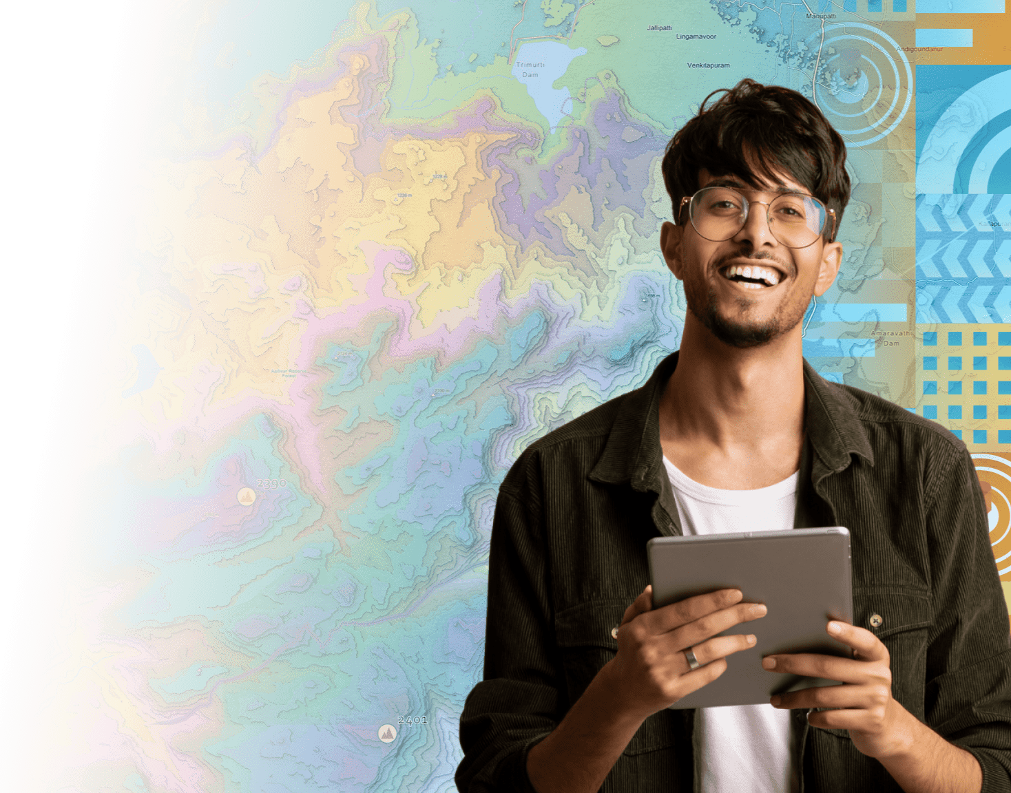 A men wearing a dark shirt smiling near artwork representing Esri India UC 2025