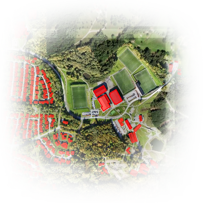 Satellite image of land with extracted buildings colored red and green land and trees