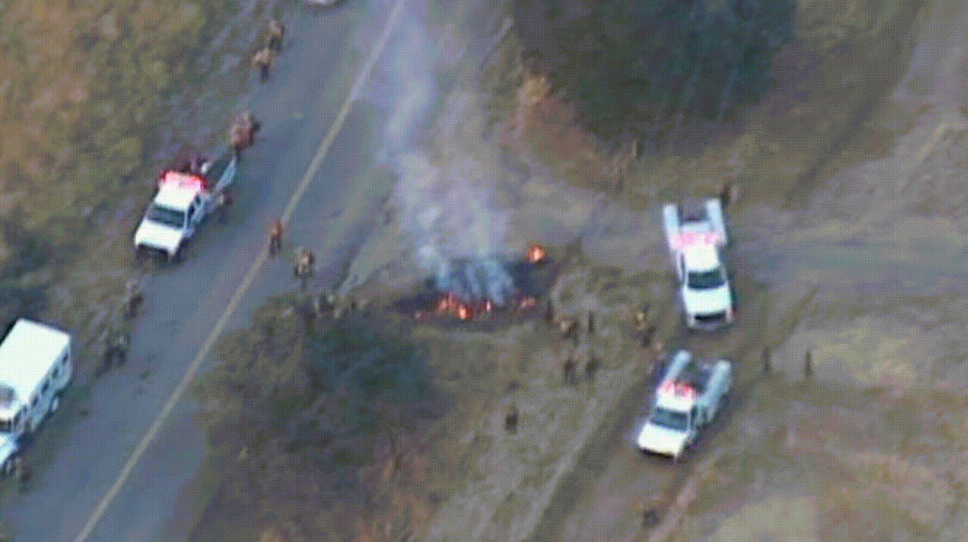 Drone footage of a fire on a highway with emergency response vehicles,Drone footage of a fire on a highway with emergency response vehicles