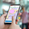 Person on a cell phone using an indoor app with positioning to navigate in real-time, finding their location with beacon hardware.