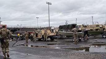 Photograph of military personnel in a lot with various military vehicles