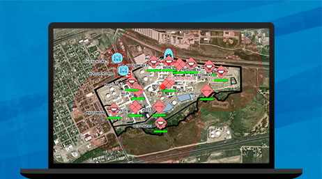 A graphic of a laptop monitor displaying an aerial photo of a city with structures and features labeled in red and blue