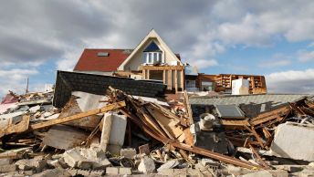 A heavily damaged structure against a partly cloudy sky