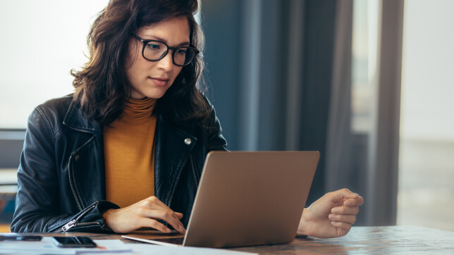 Person sitting at a desk and looking at a laptop screen